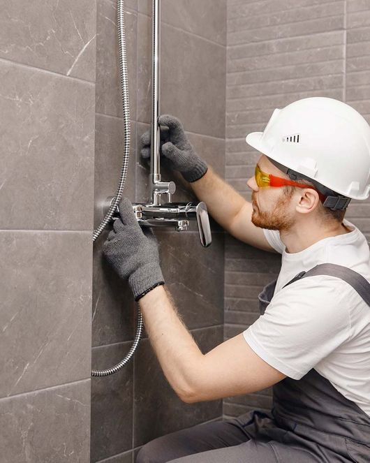 Installateur installiert Armatur in Dusche